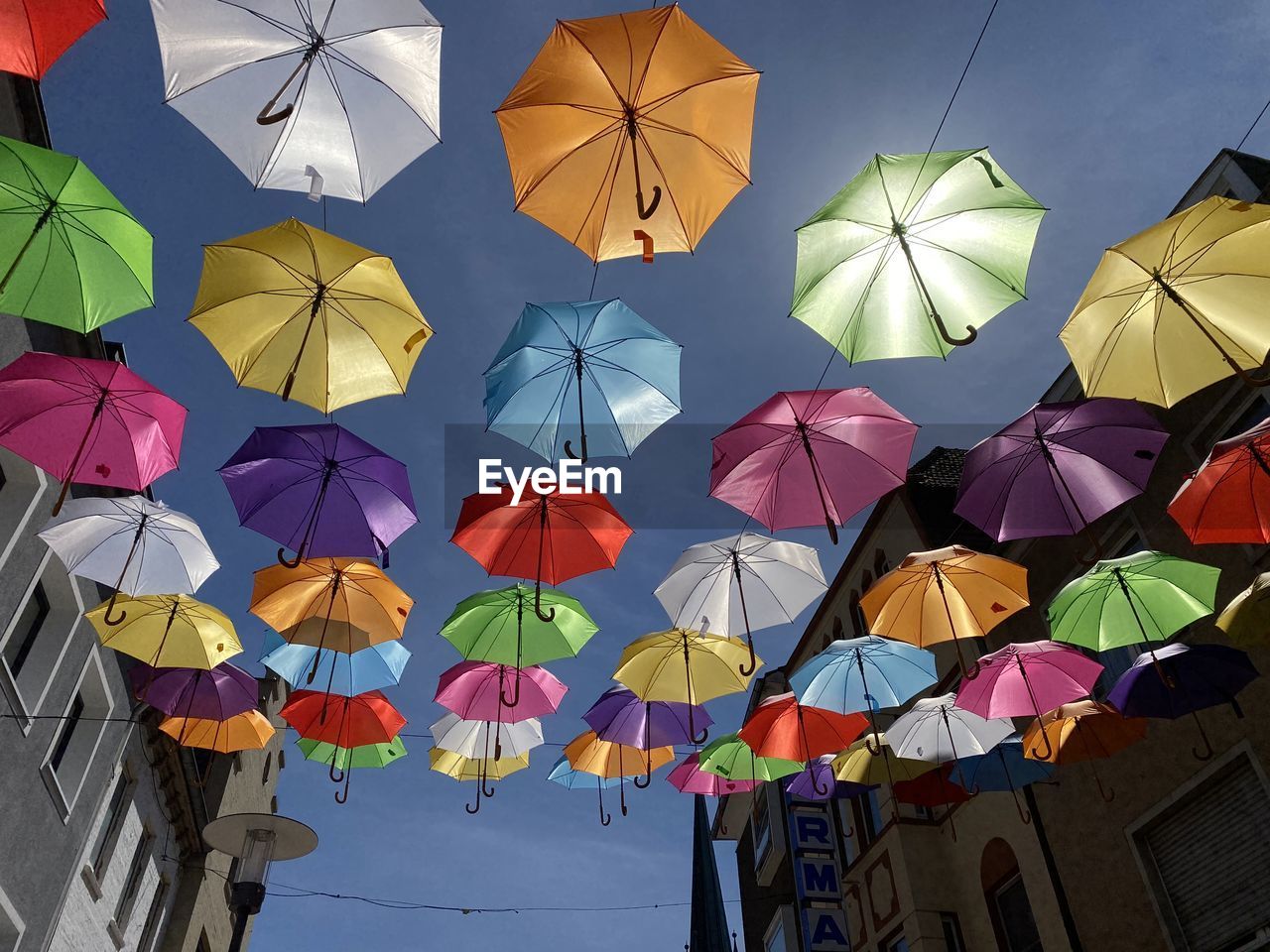 LOW ANGLE VIEW OF MULTI COLORED UMBRELLAS AGAINST SKY