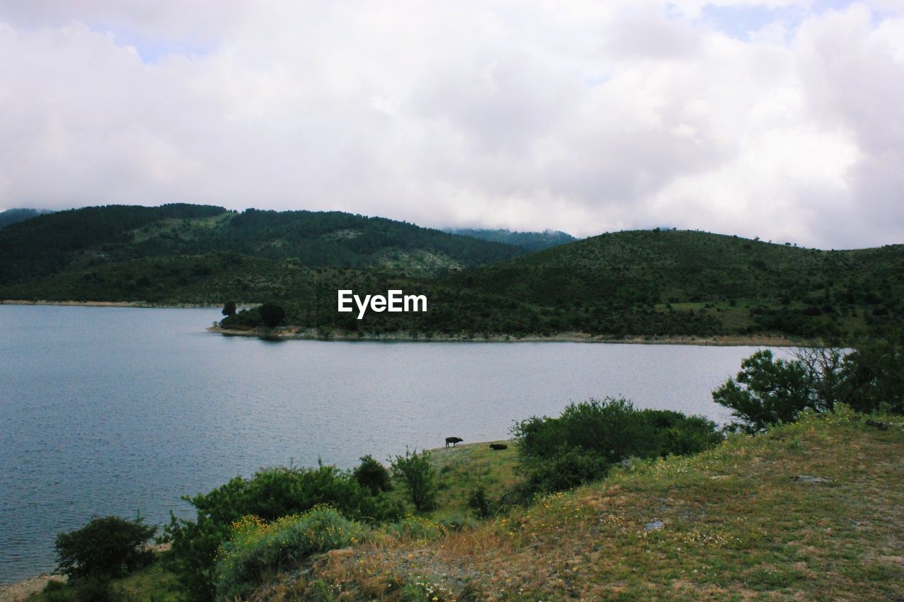 SCENIC VIEW OF LAKE BY MOUNTAIN AGAINST SKY