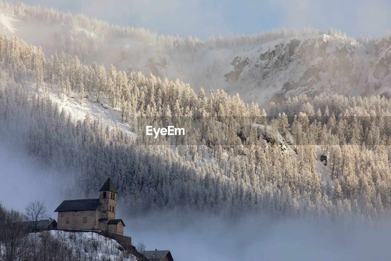 Panoramic view of snow covered mountains against sky