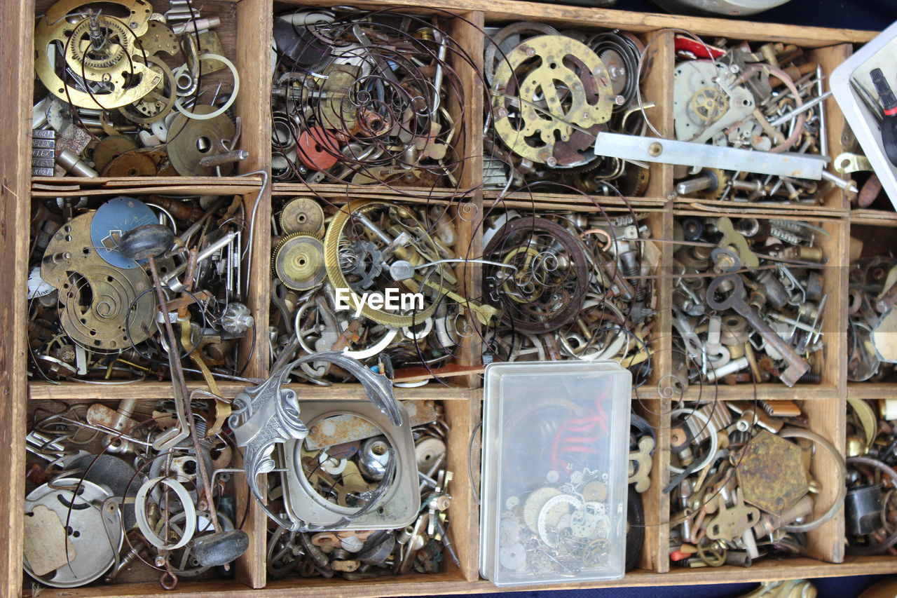 Close-up of various machine parts in wooden container