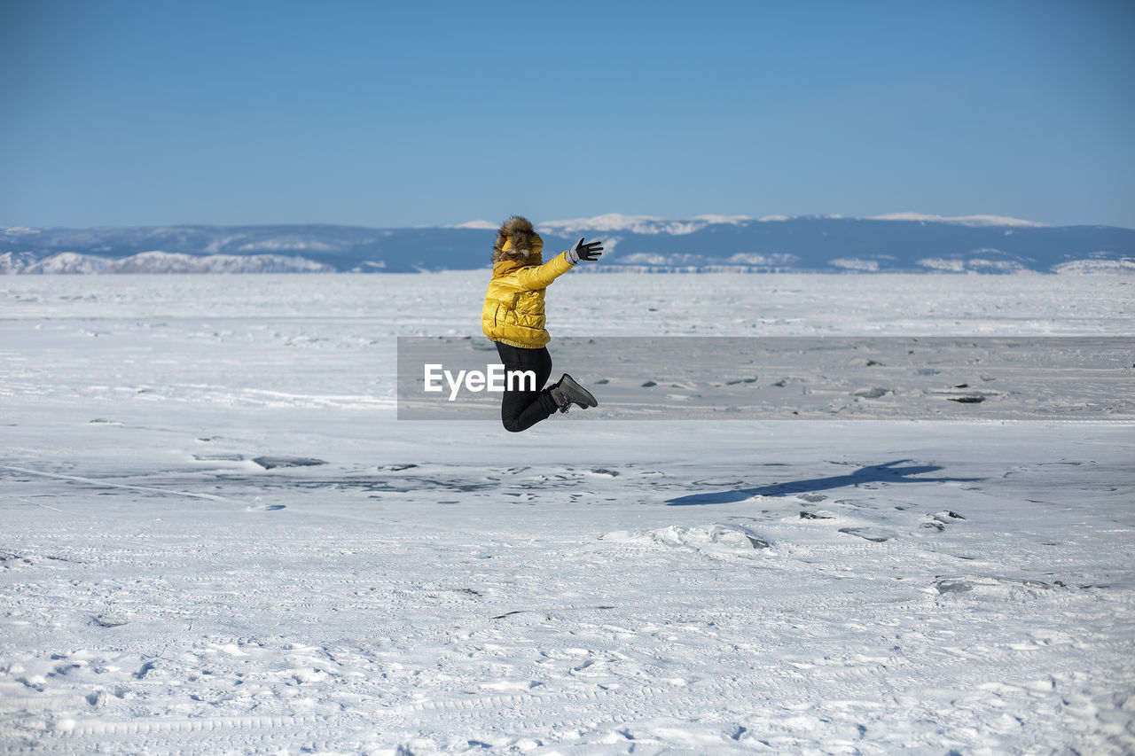 full length of woman standing on snow