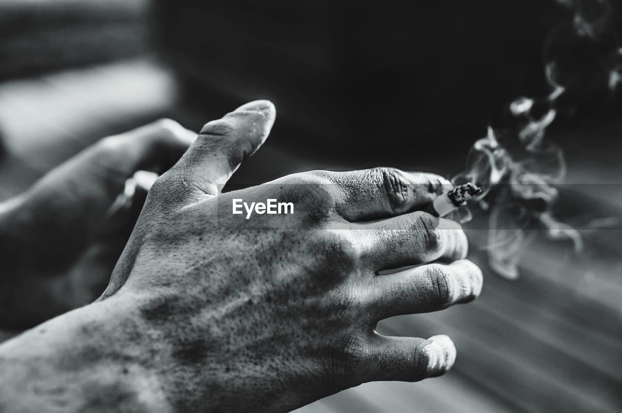 Close-up of a hand holding cigarette