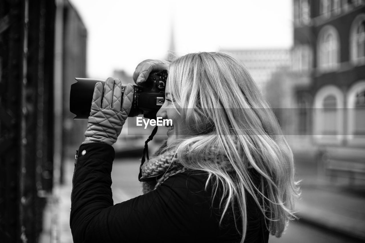 Side view of a blonde female photographer. 