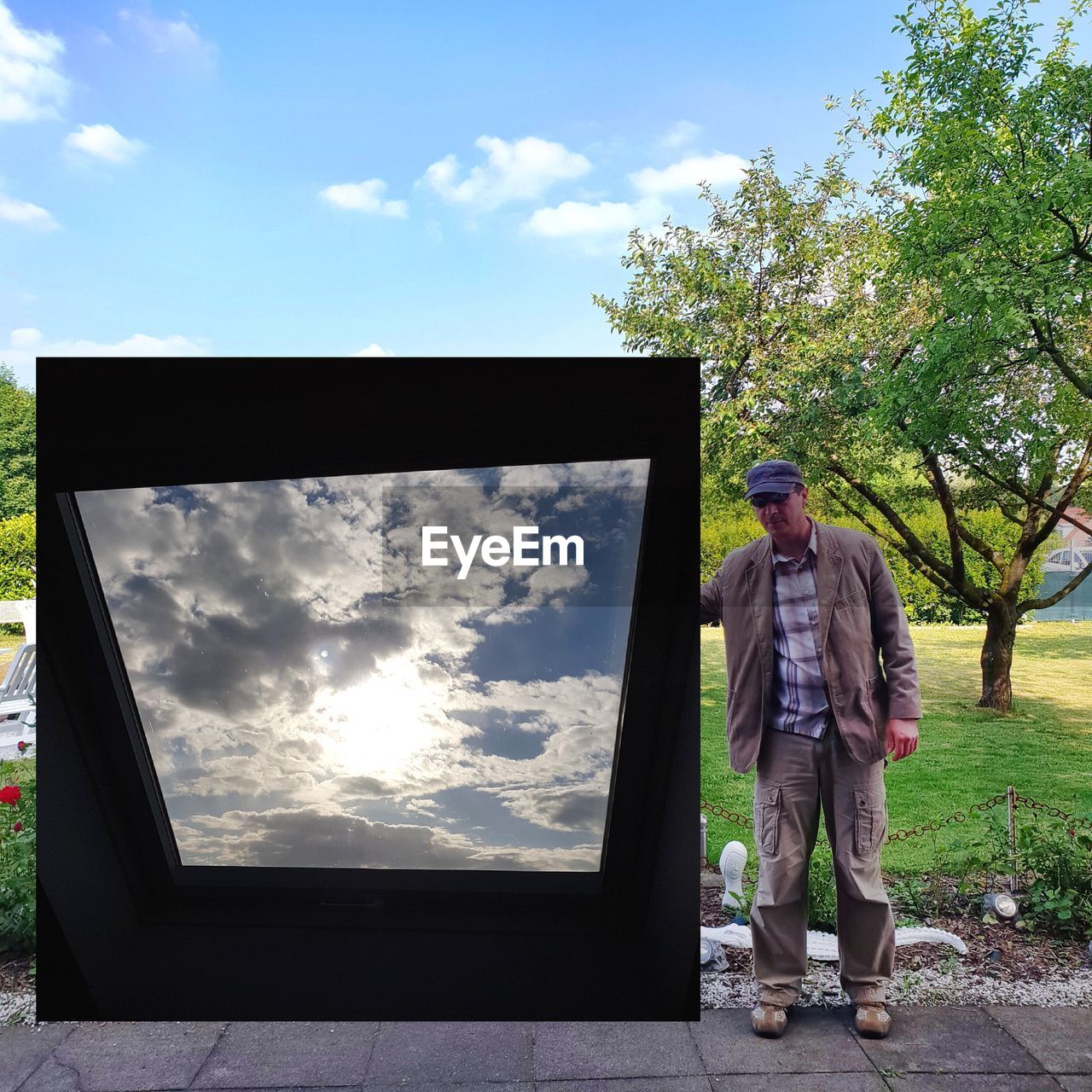 Full length of man standing by photograph against sky