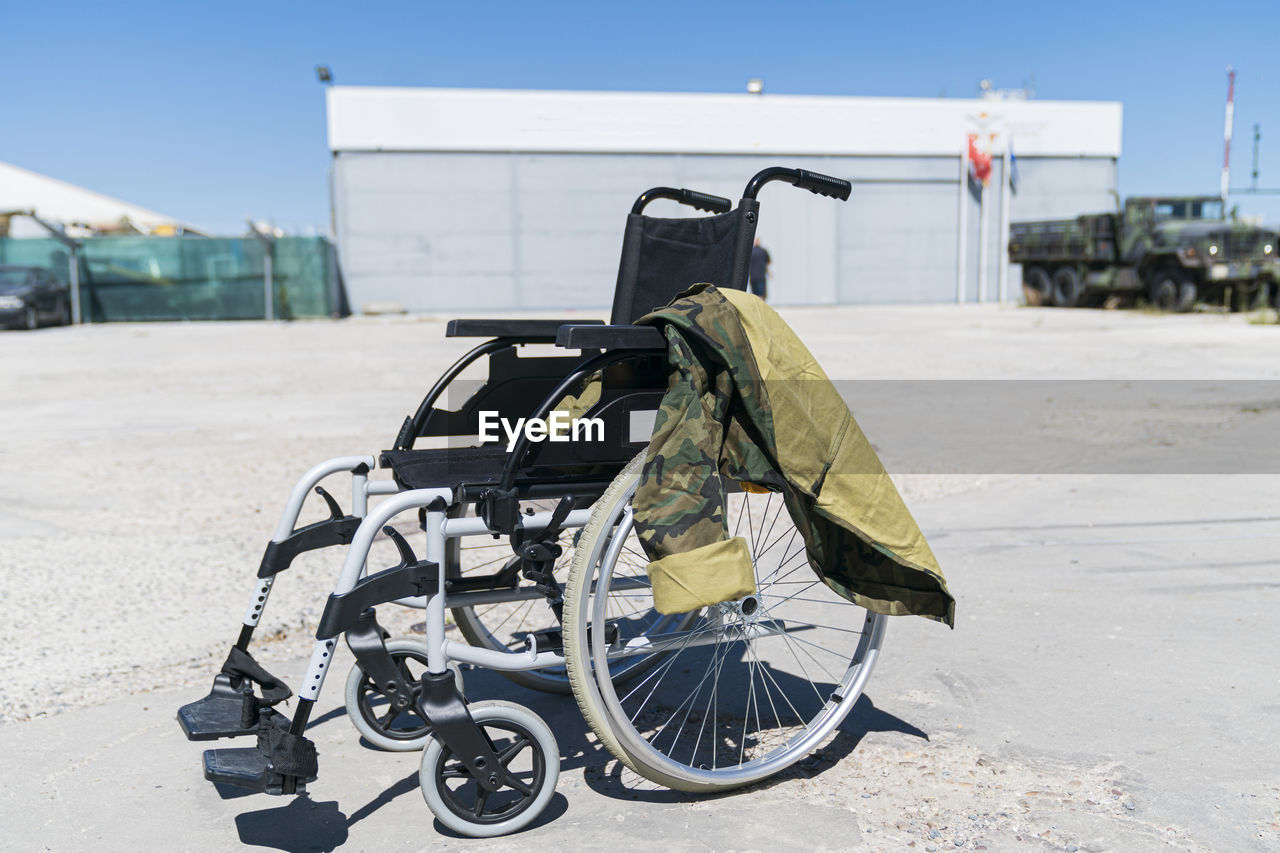 Military uniform on empty wheelchair at military base during sunny day