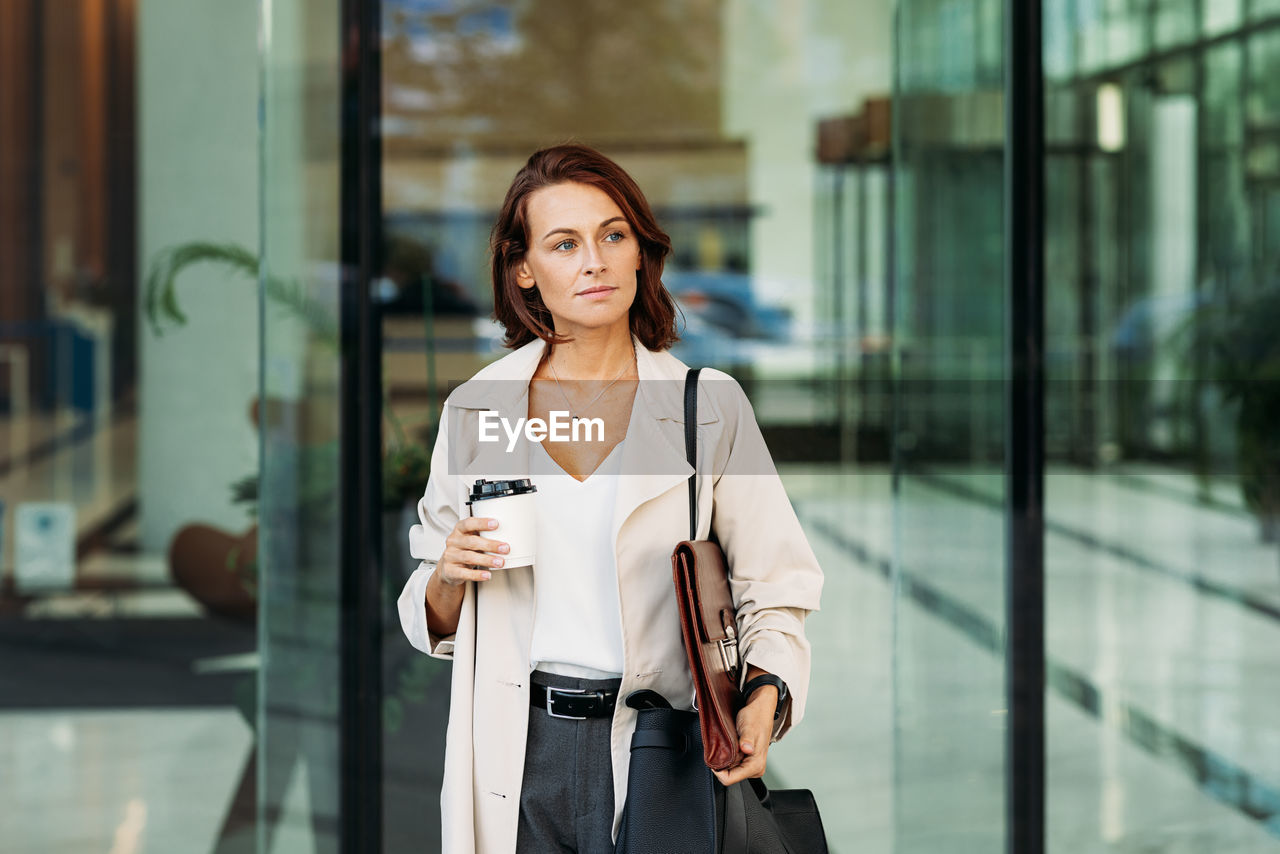 portrait of young woman standing against building