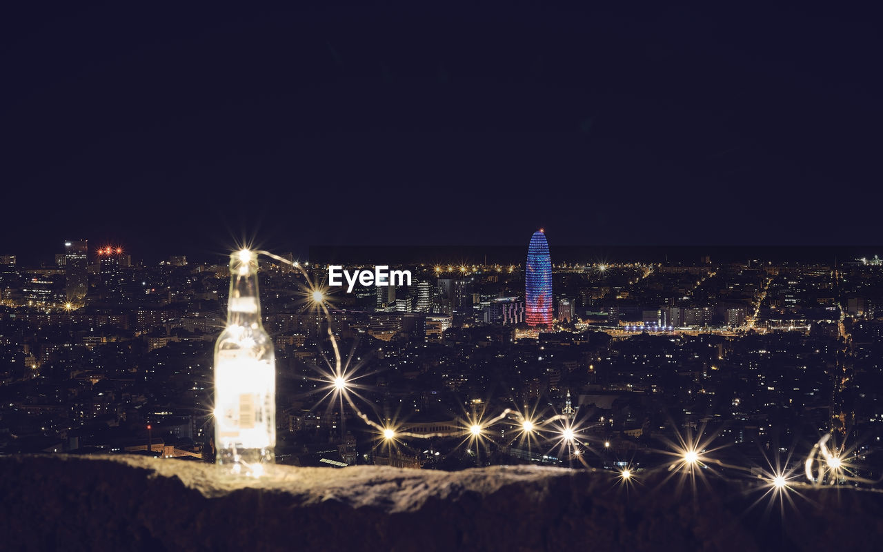 ILLUMINATED CITYSCAPE AGAINST CLEAR SKY DURING WINTER