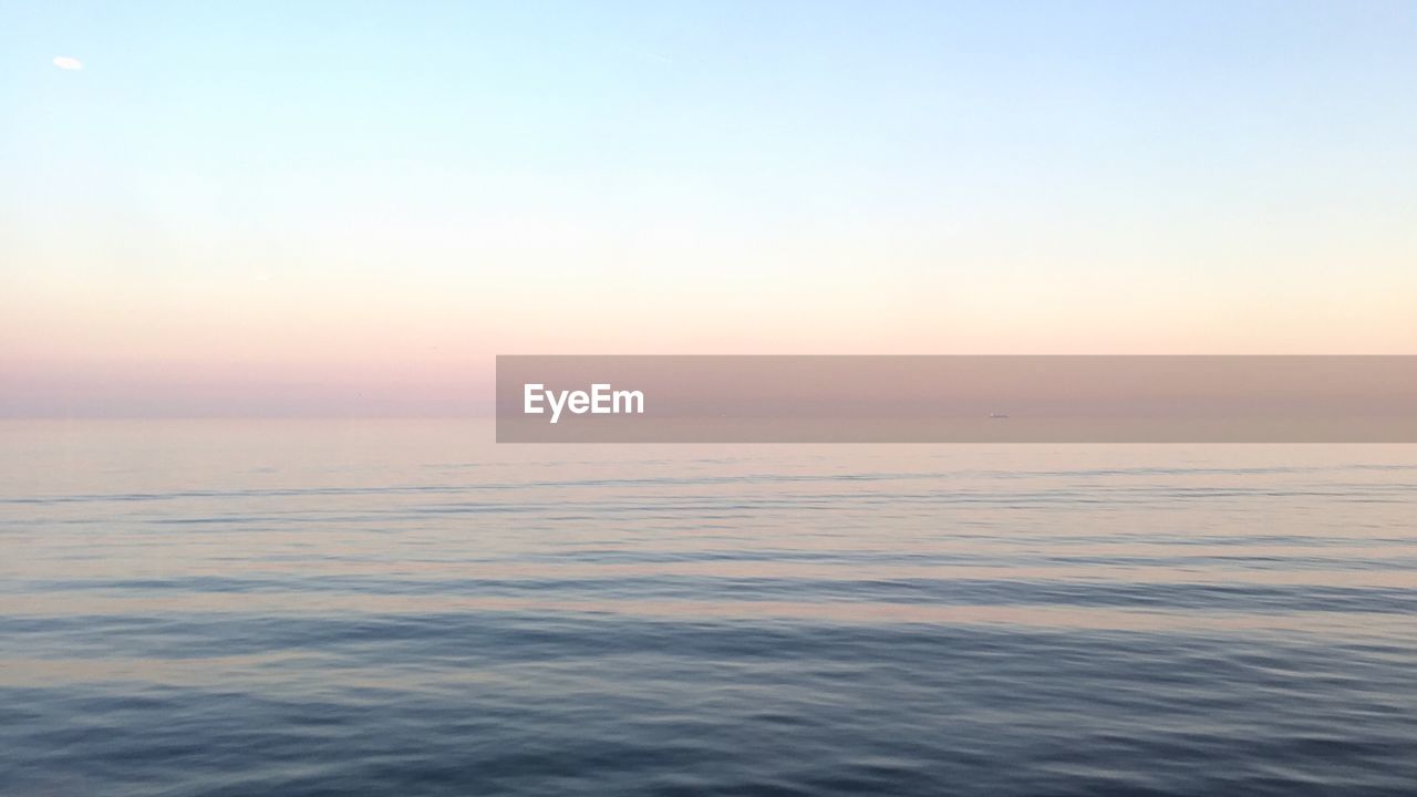 Scenic view of seascape against clear sky during sunset