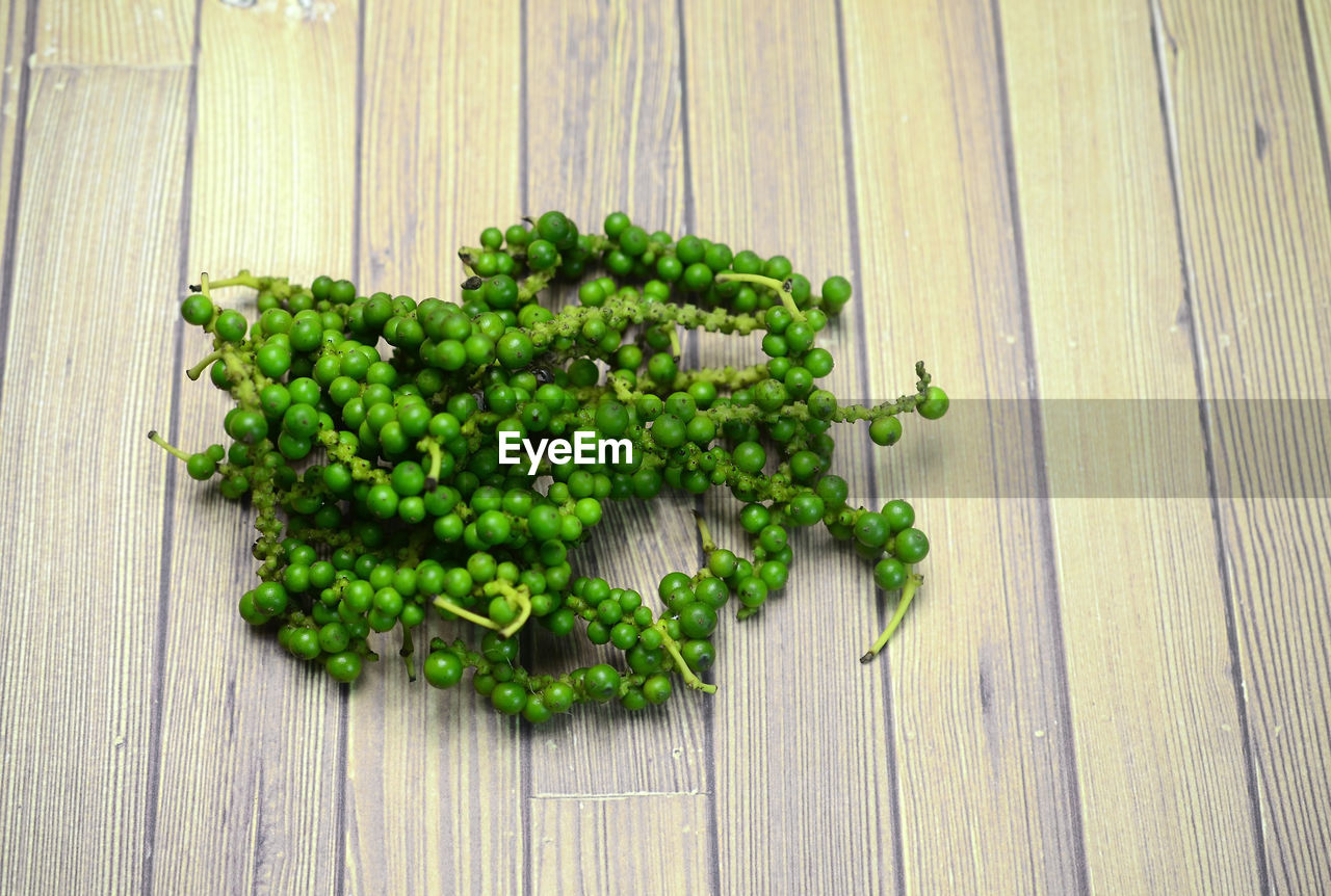 Bunch of green peppercorn on wooden table background