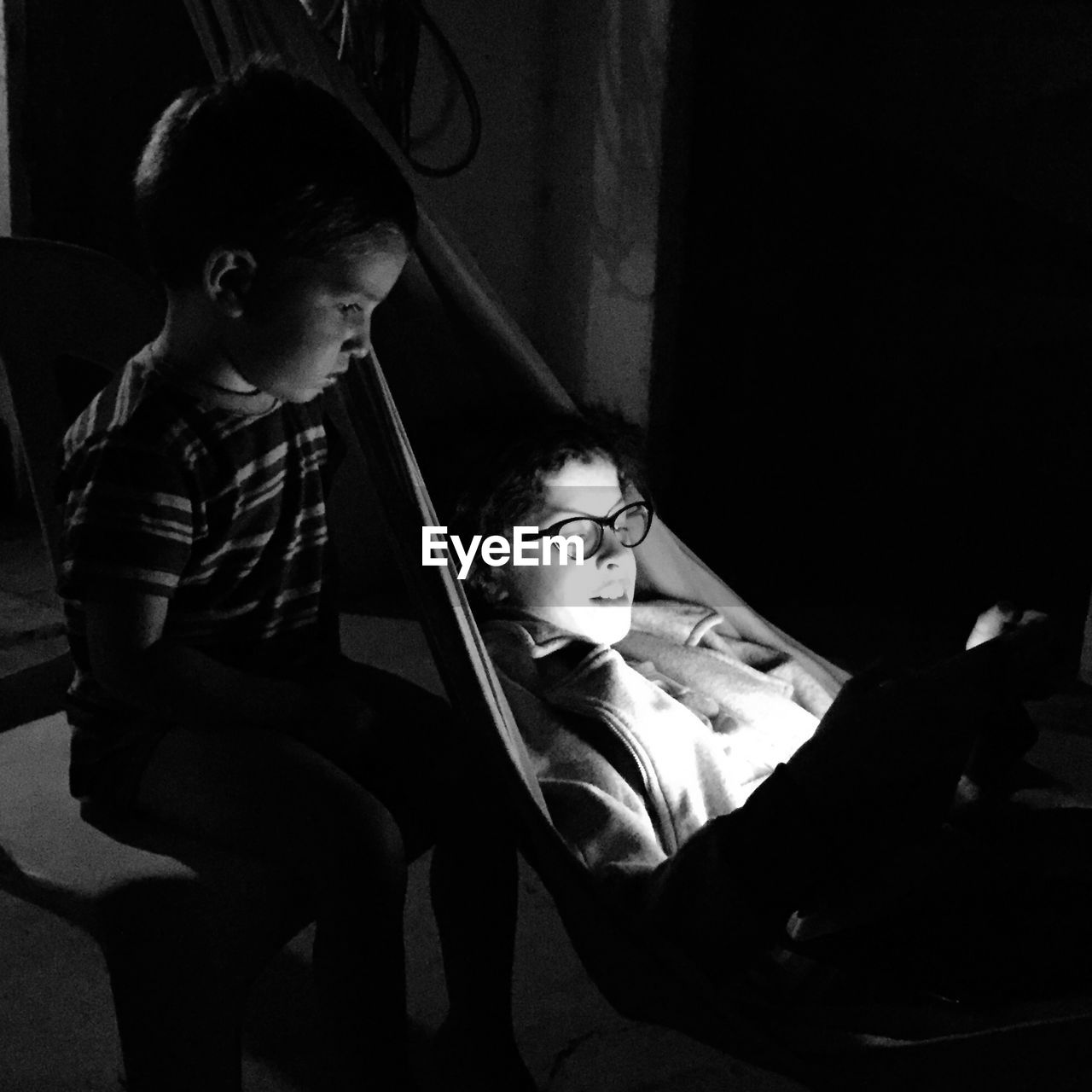 Sibling sitting in dark at home