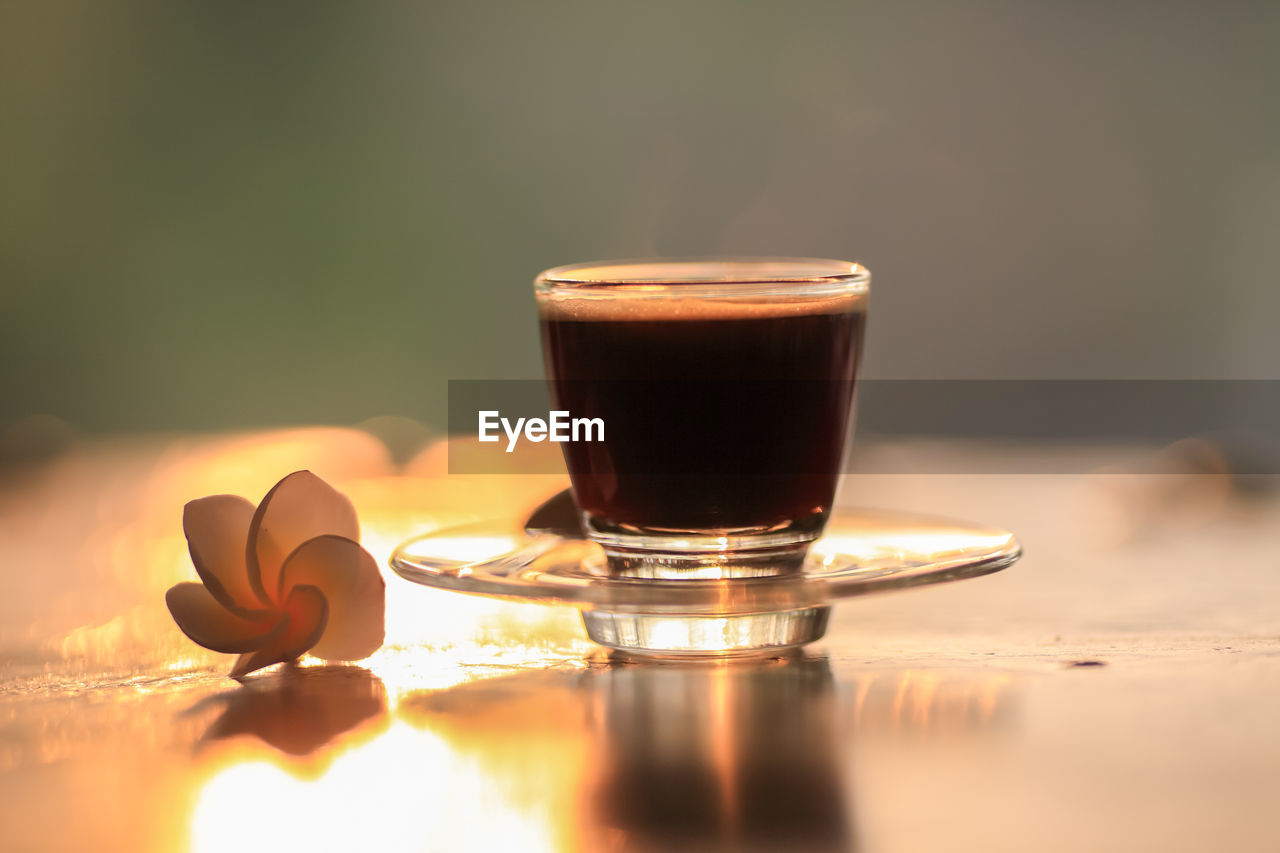 CLOSE-UP OF COFFEE WITH GLASS ON TABLE