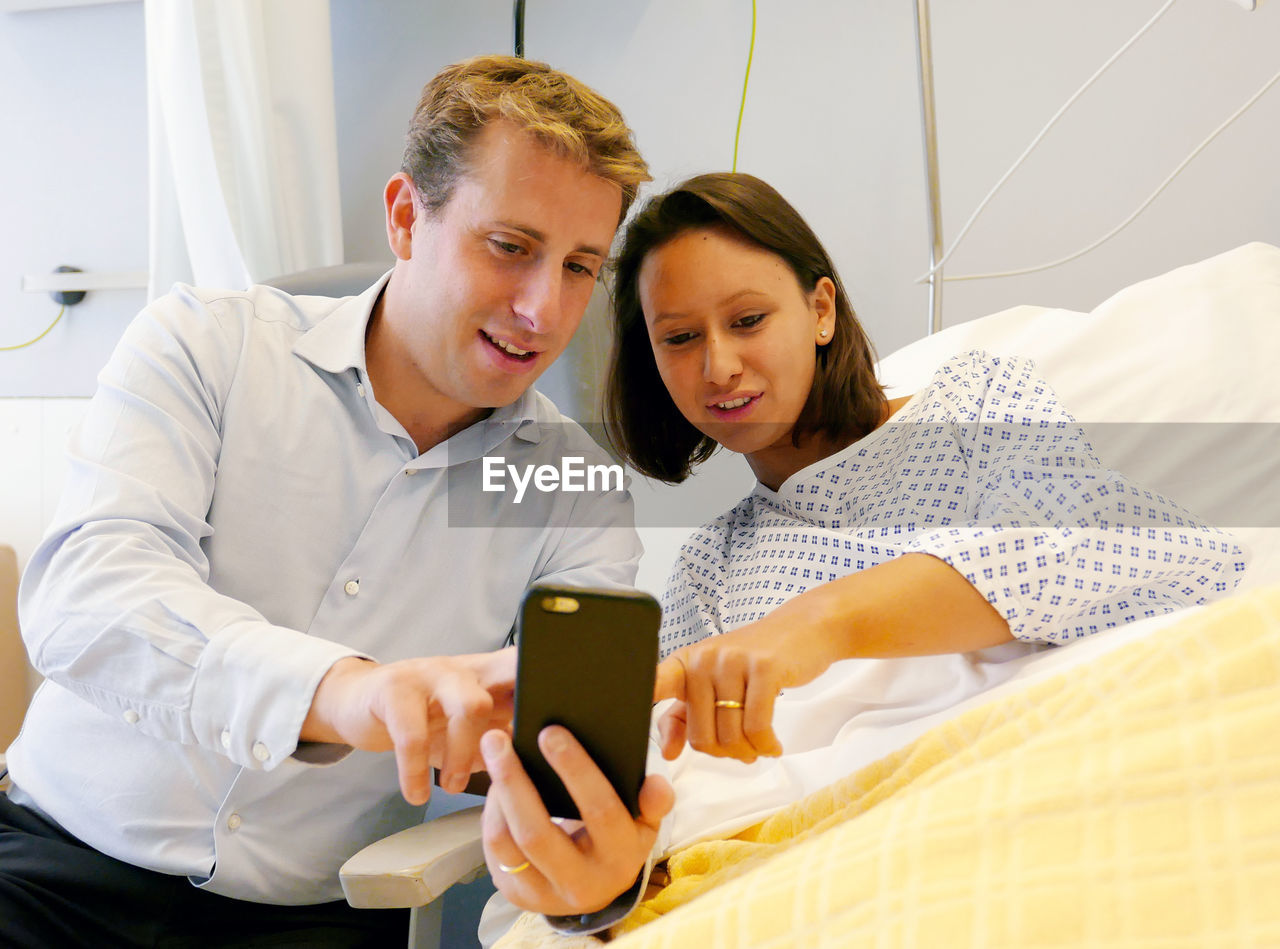 Couple using mobile phone at hospital