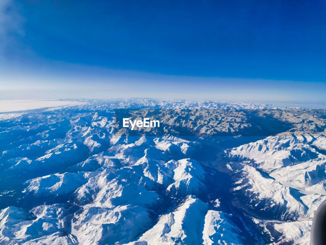 Scenic view of snowcapped mountains against blue sky