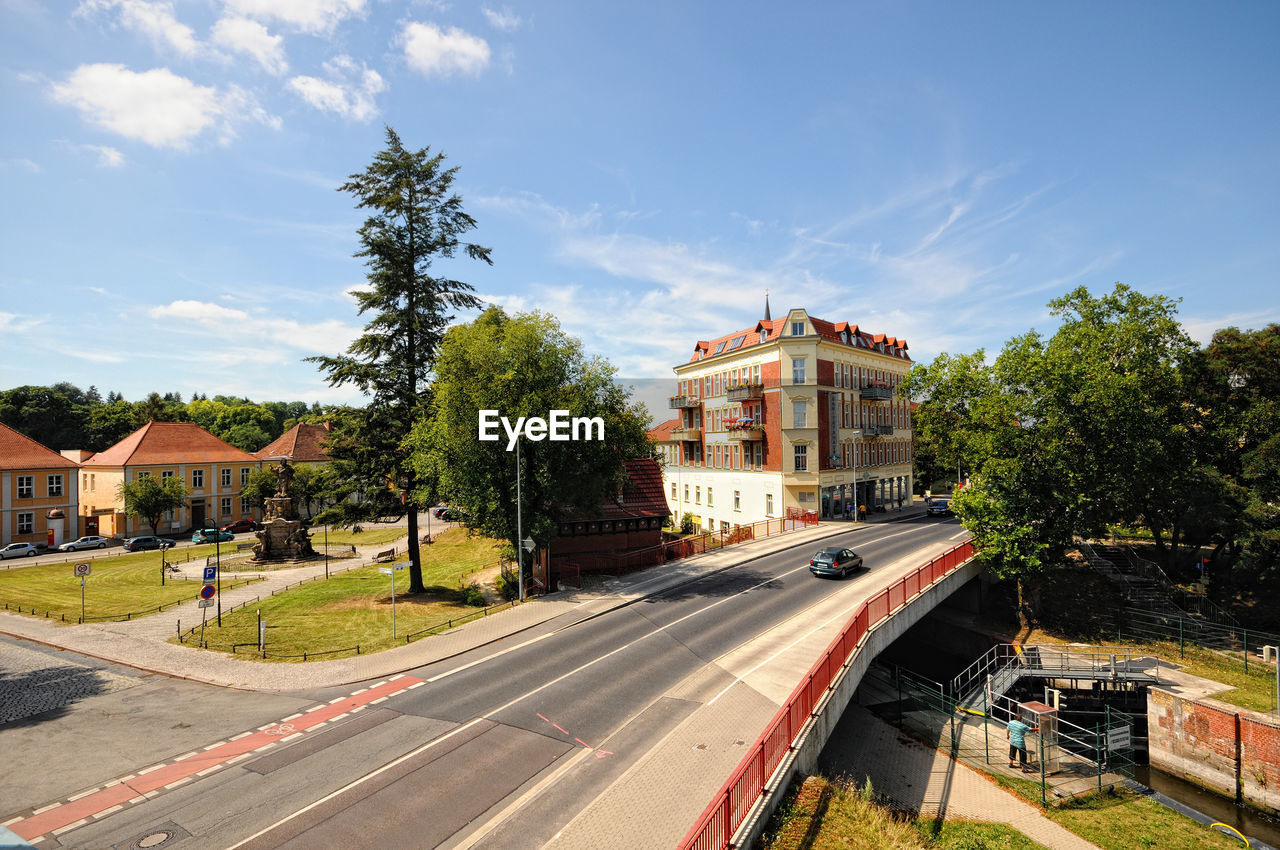 VEHICLES ON ROAD ALONG BUILDINGS