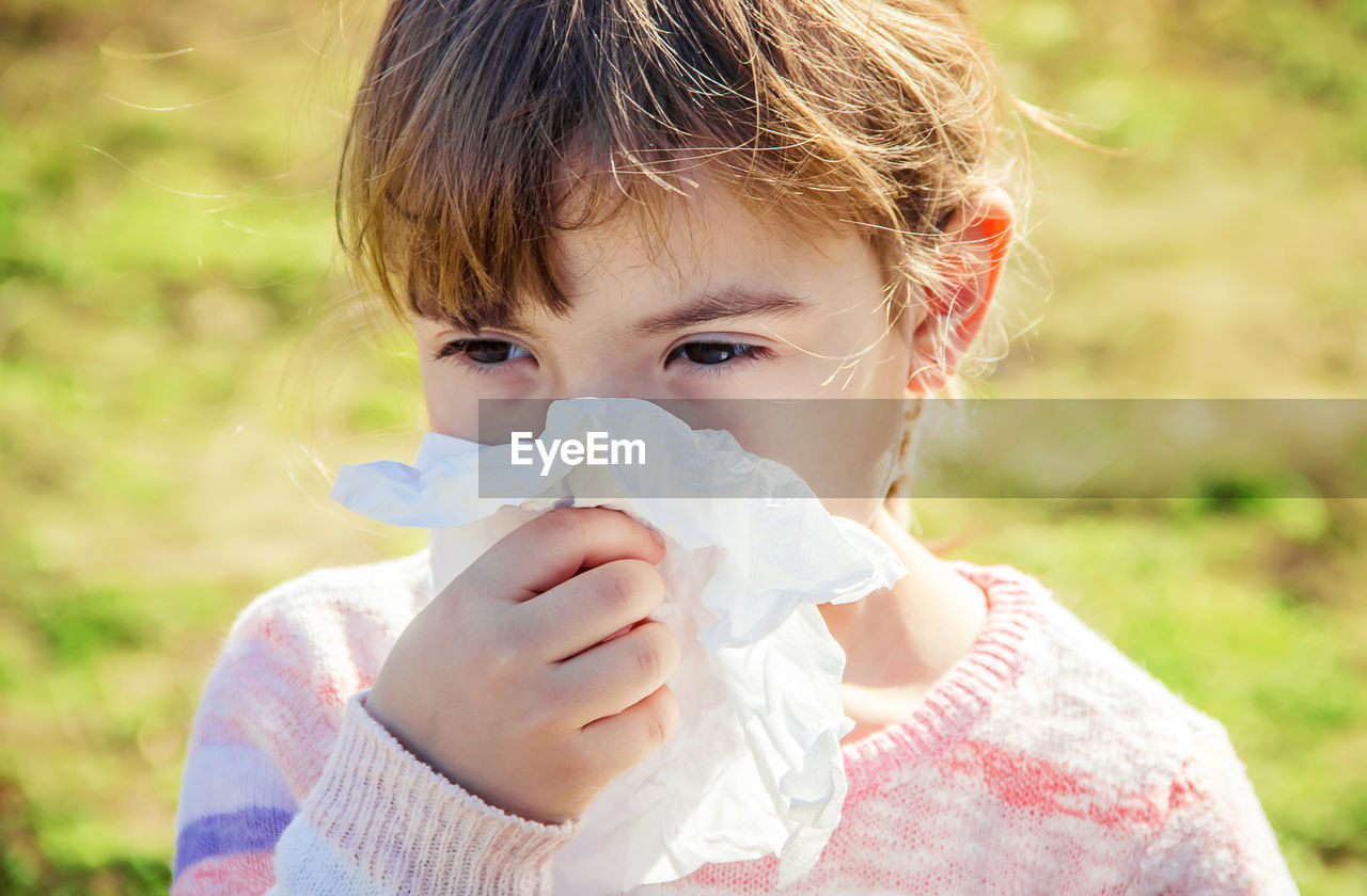 close-up of cute girl blowing bubbles in park