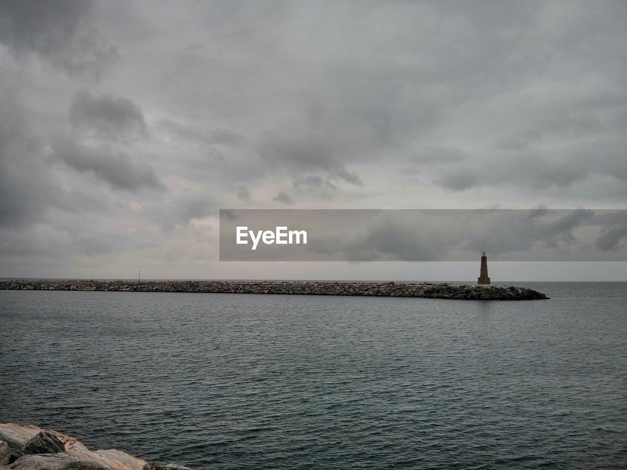 Scenic view of calm sea against cloudy sky