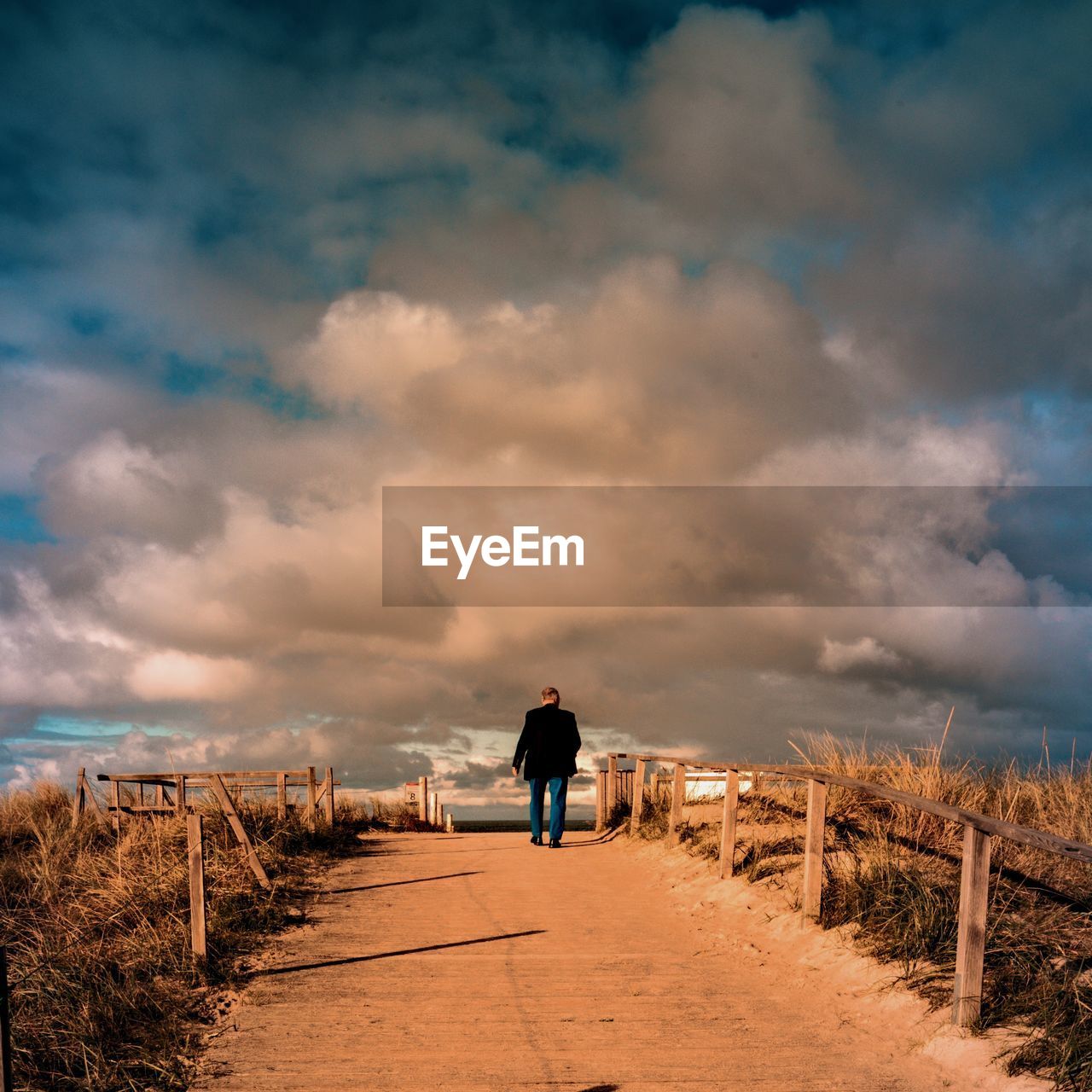 Rear view of man standing on land against sky