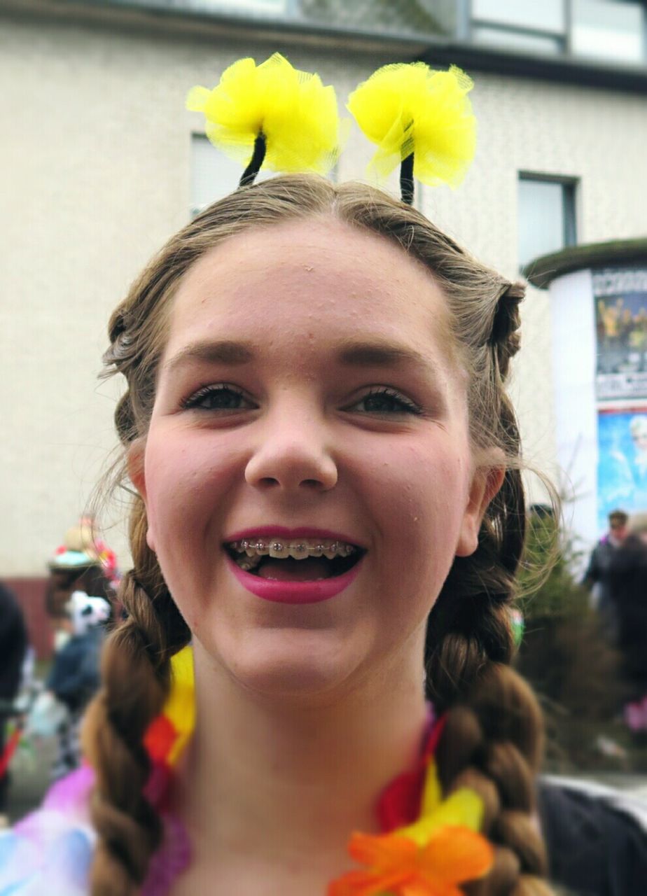 Portrait of smiling teenage girl wearing flowers during carnival