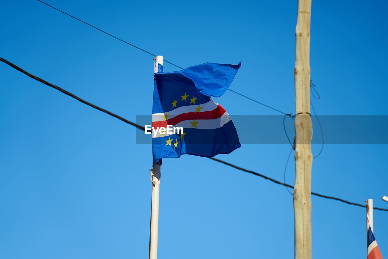 blue, flag, sky, pole, clear sky, nature, wind, patriotism, low angle view, environment, mast, day, no people, sunny, outdoors, sunlight, striped, rope, hanging