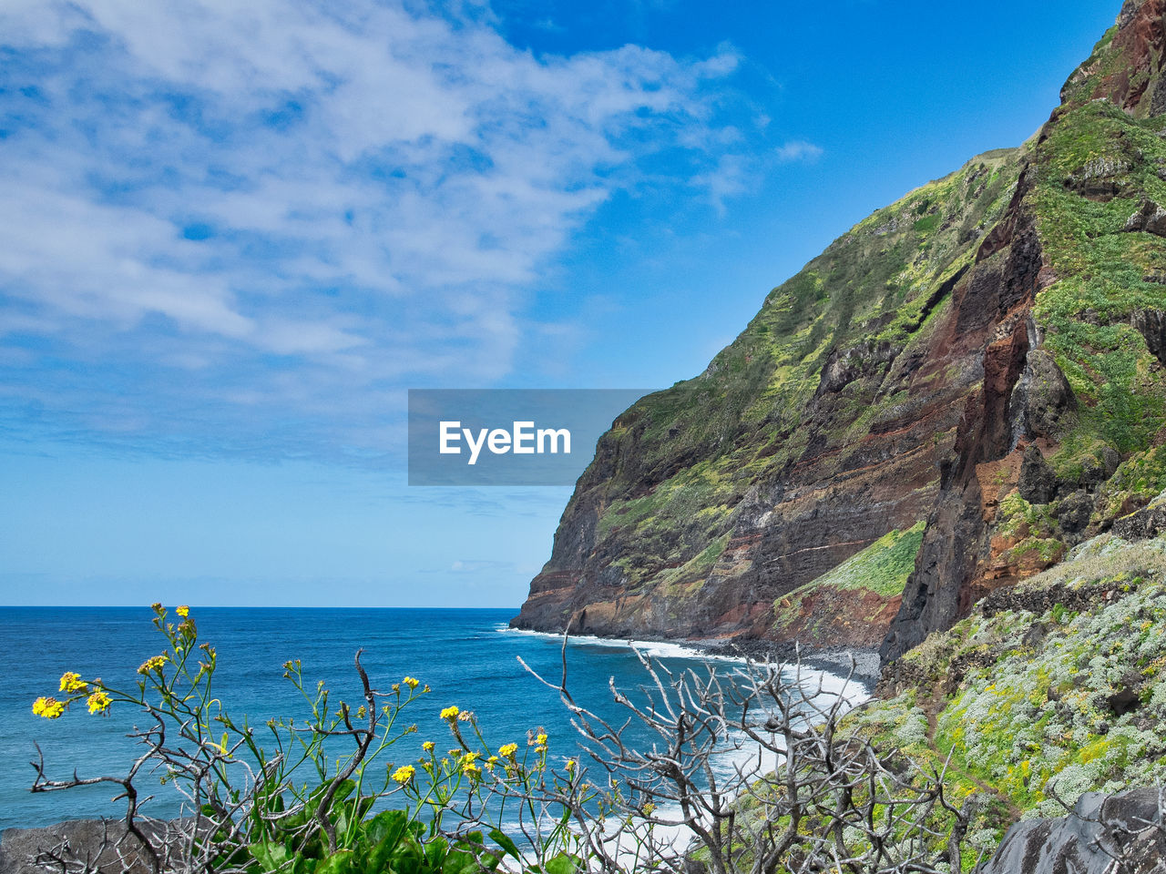 SCENIC VIEW OF SEA BY MOUNTAINS AGAINST SKY