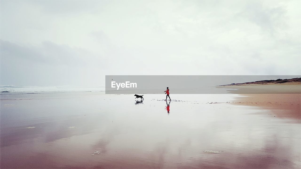 MEN ON BEACH AGAINST SKY