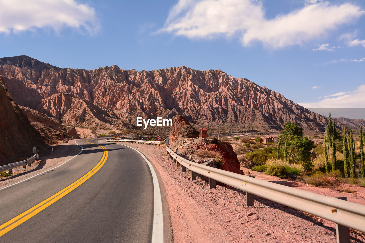 Road by mountain against sky