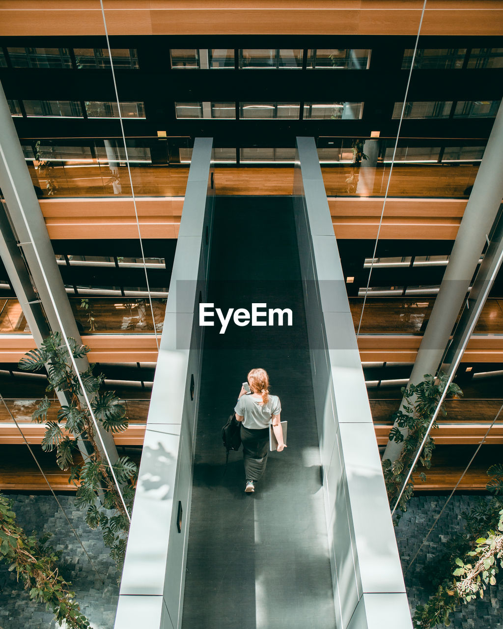 HIGH ANGLE VIEW OF WOMAN ON STAIRCASE IN BUILDING