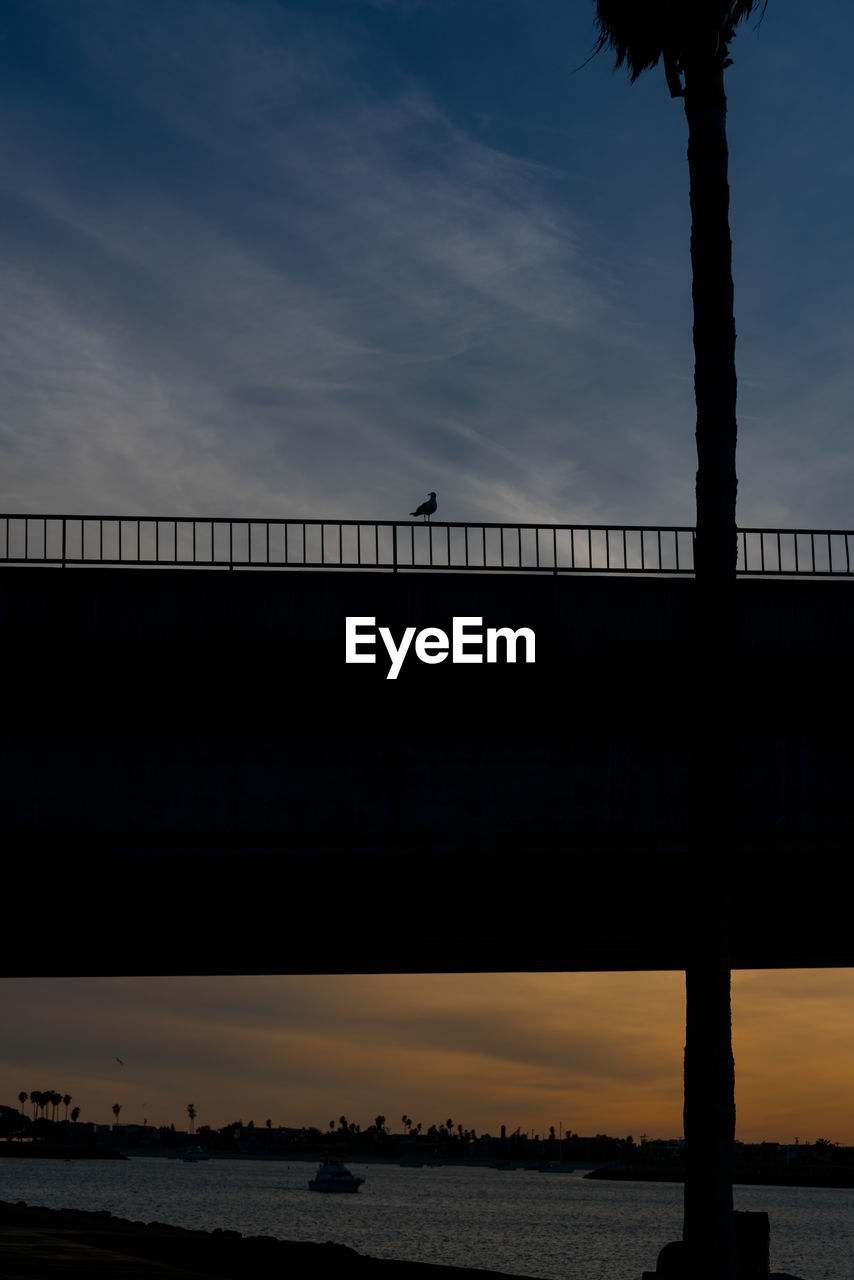 SILHOUETTE BRIDGE OVER RIVER AGAINST SKY