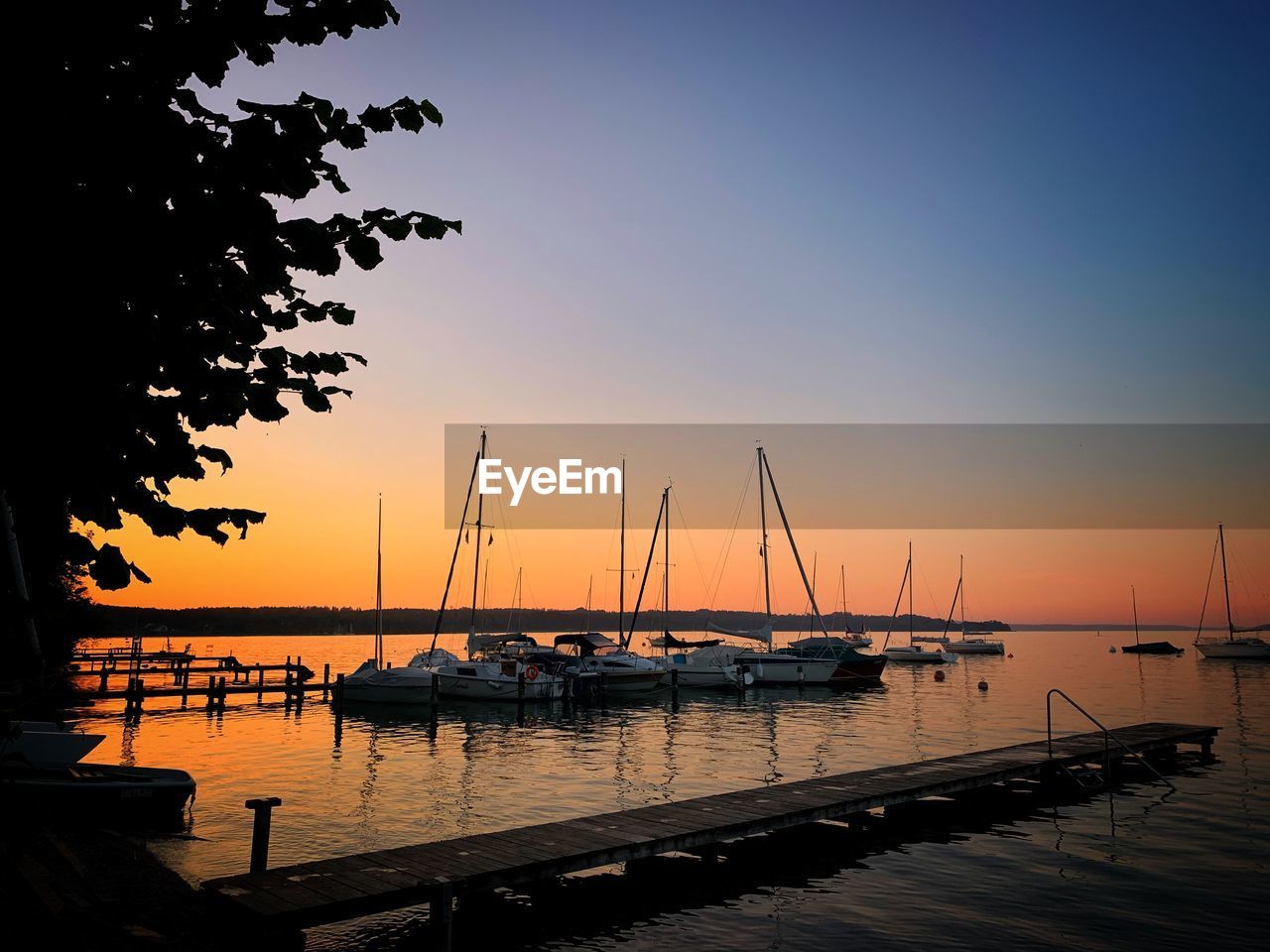 BOATS MOORED IN MARINA AT SUNSET