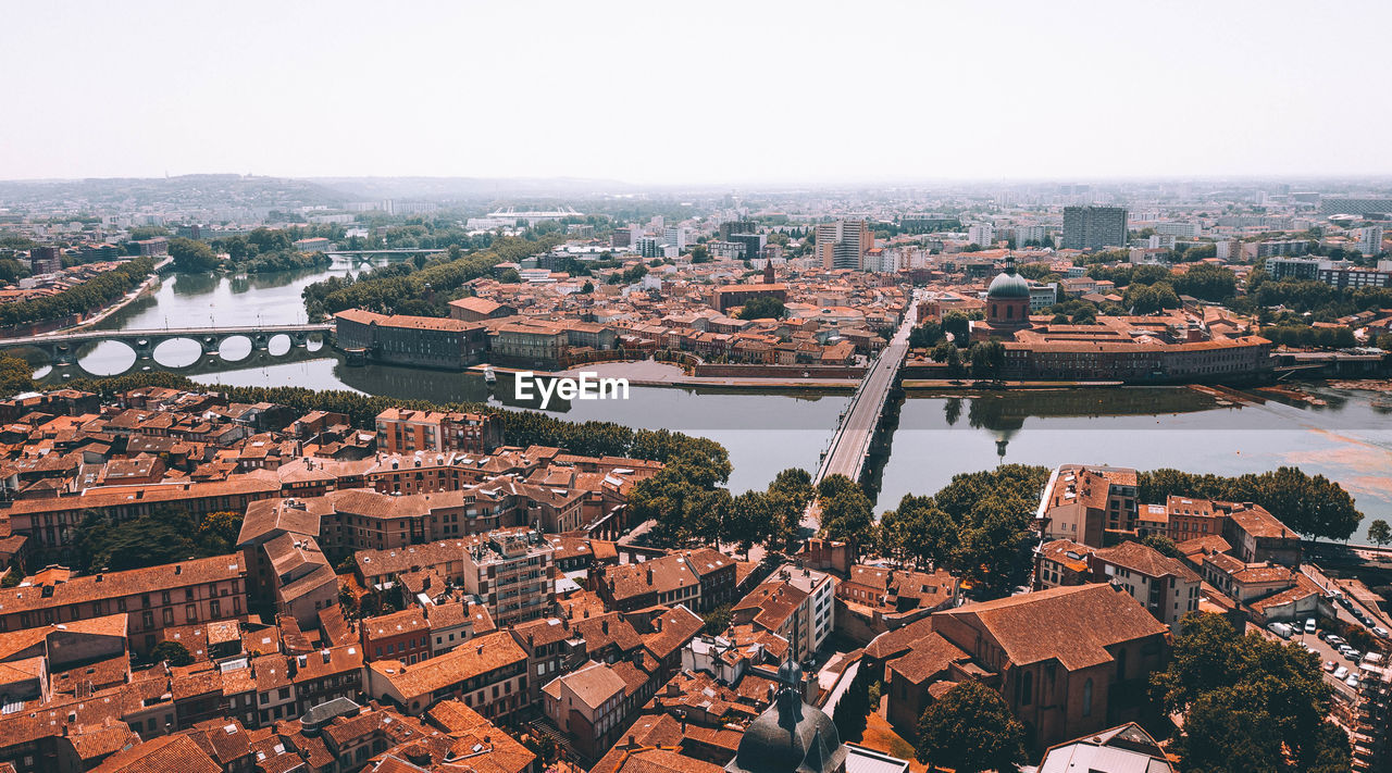 High angle view of river in city against clear sky