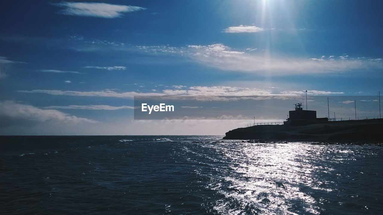 View of sea with lighthouse at coast