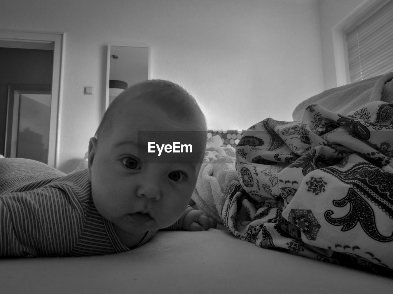 Portrait of cute boy lying on bed at home