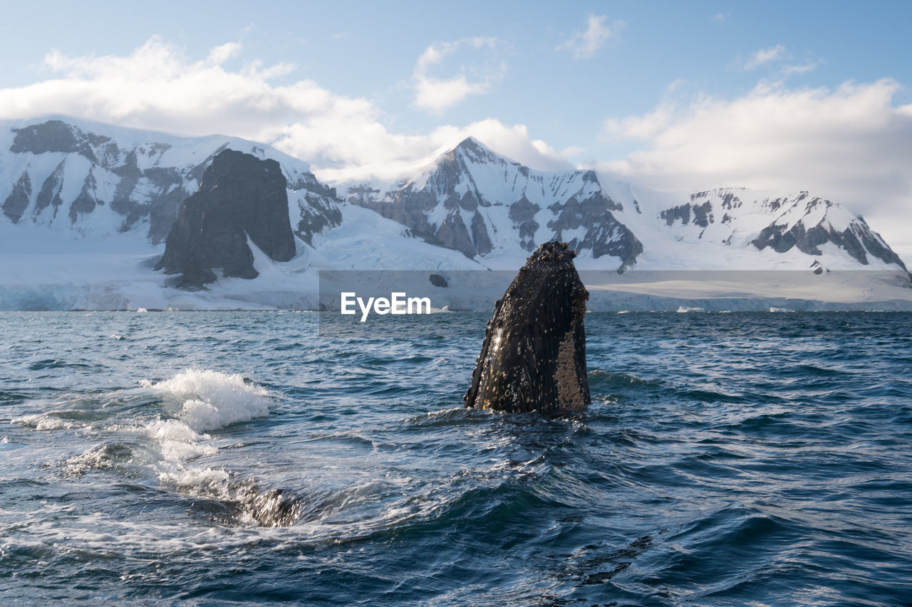 Scenic view of sea and mountains against sky