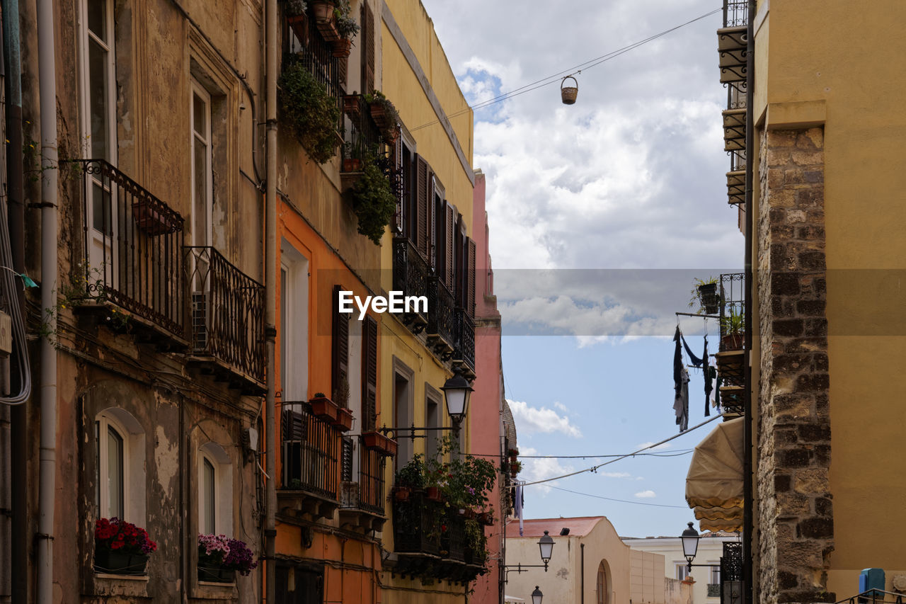 LOW ANGLE VIEW OF BUILDINGS IN TOWN AGAINST SKY