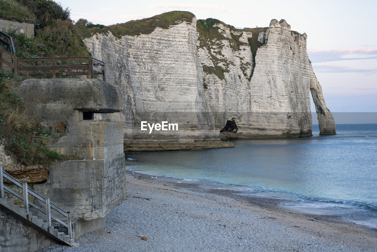 Rock formations on beach against sky