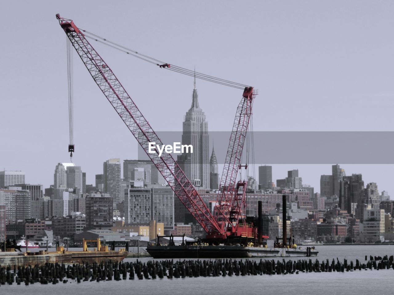 Empire state building seen through crane at commercial dock