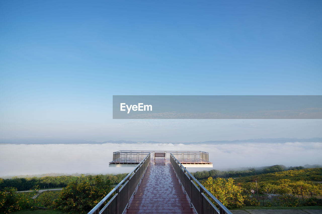 Scenic view of bridge against sky and sea of fog