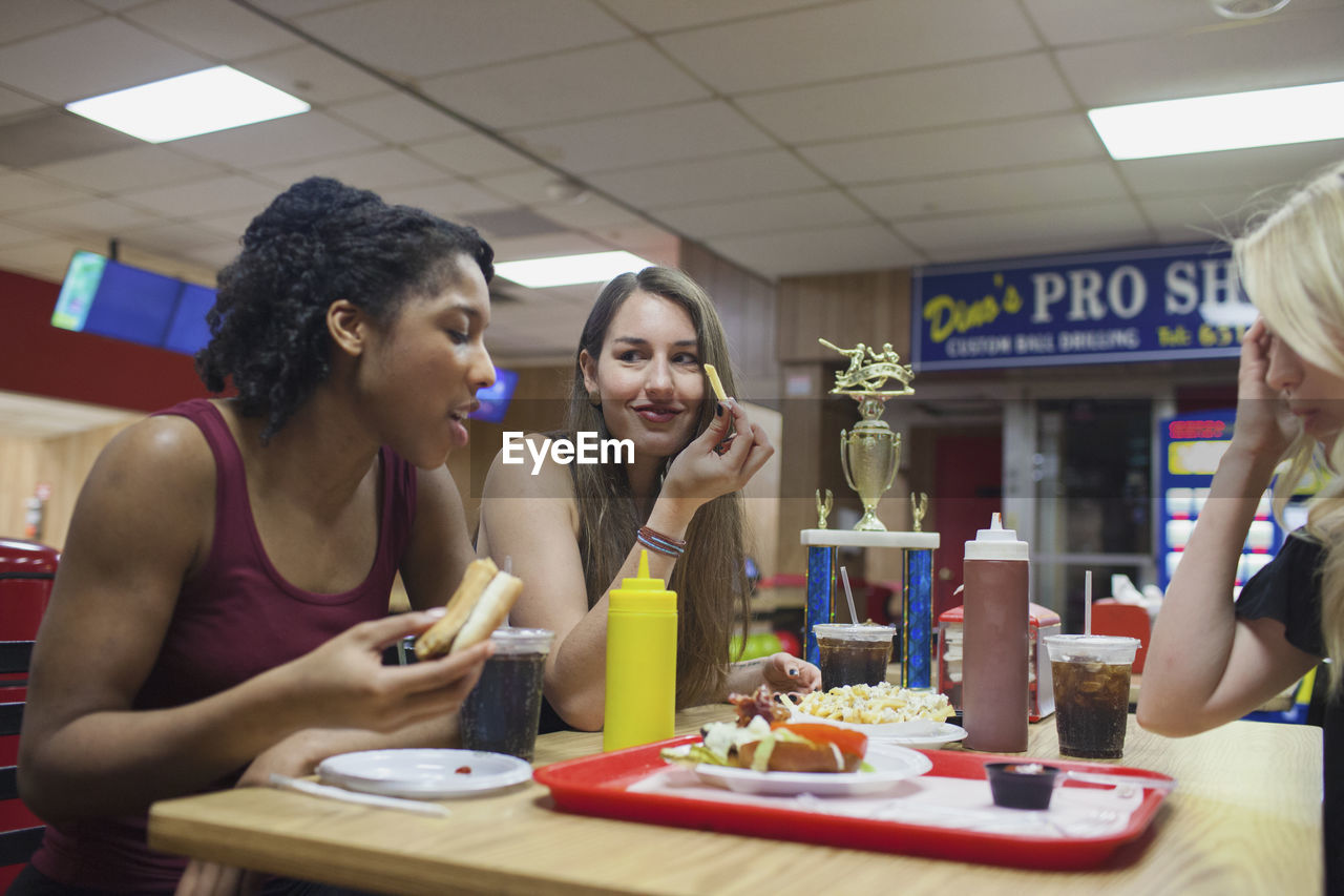 Young women eating at a diner together.