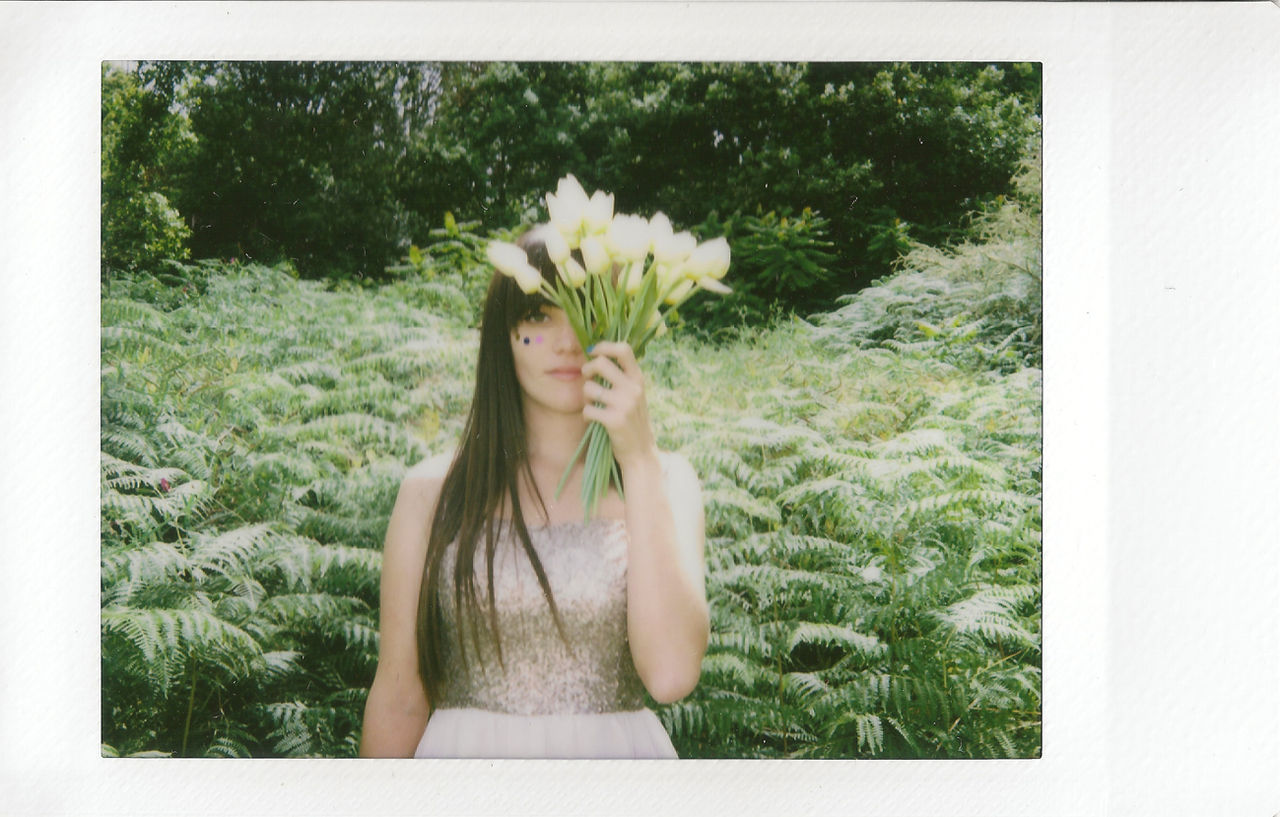Woman covering her face with flowers