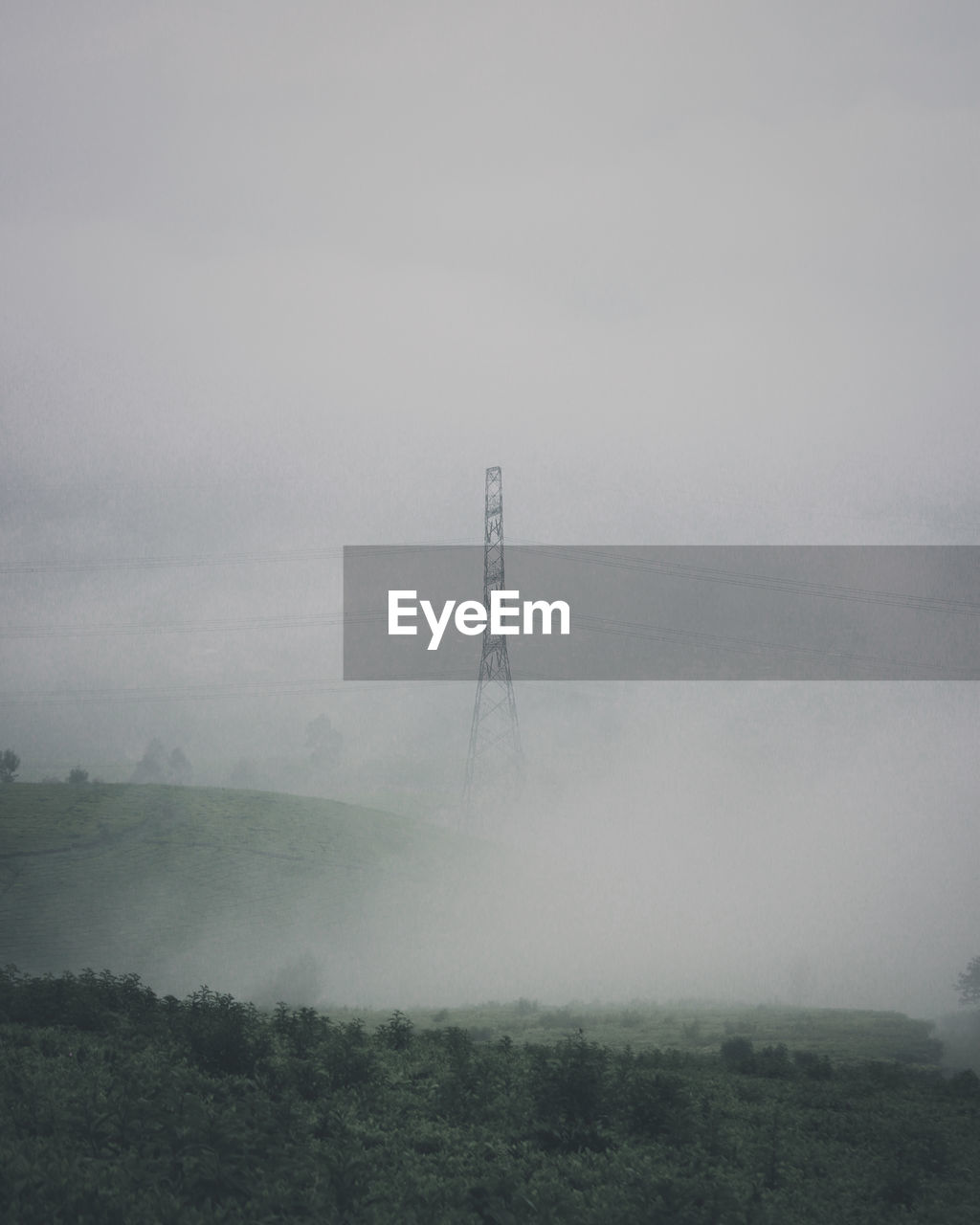 ELECTRICITY PYLON ON LANDSCAPE AGAINST SKY