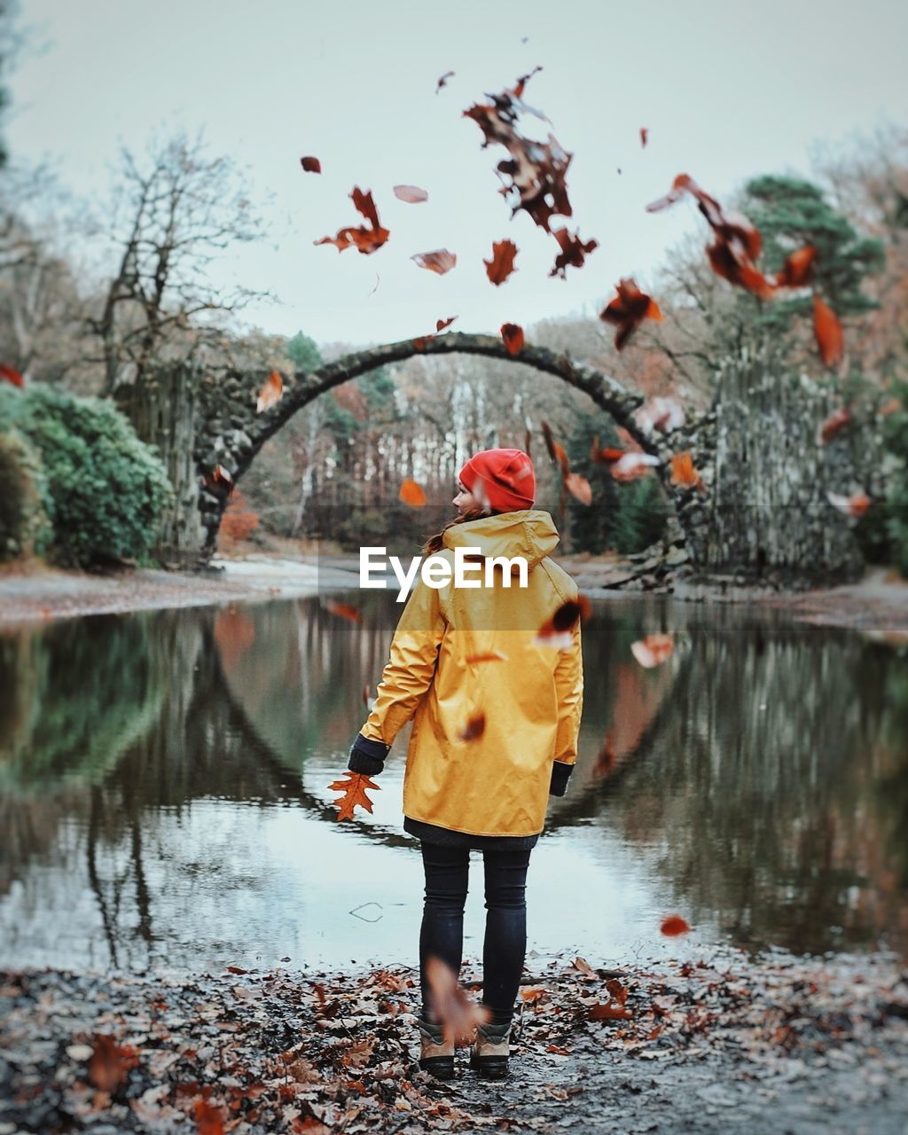 REAR VIEW OF WOMAN STANDING BY RIVER