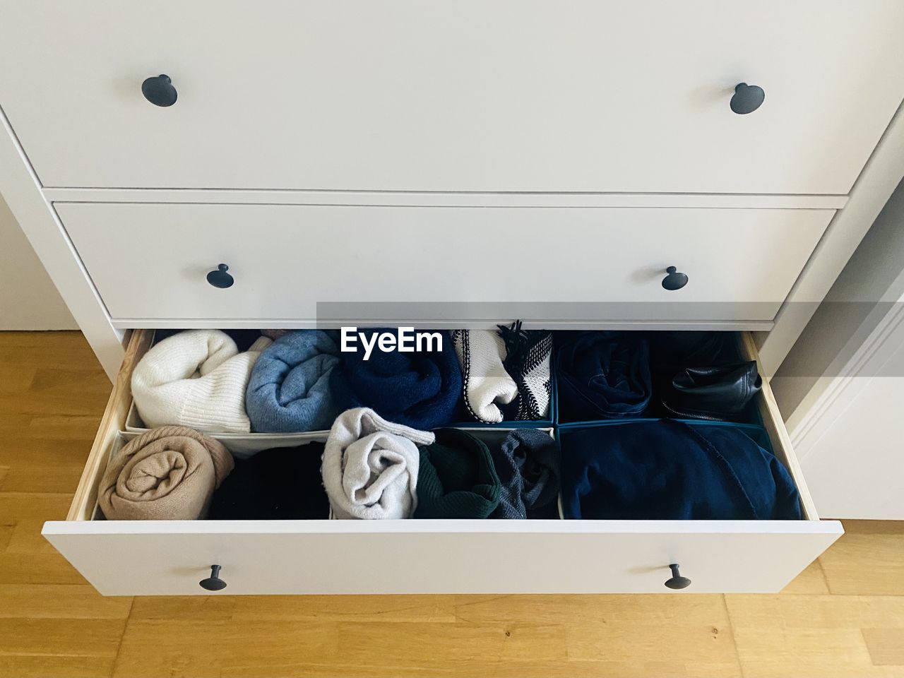High angle view of open organized drawer with clothes  at home