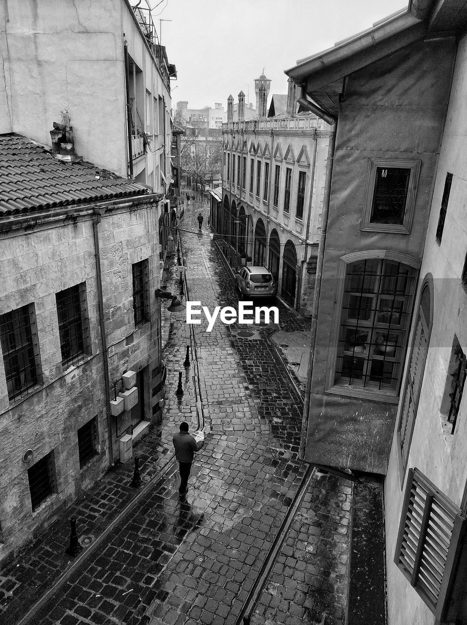 High angle view of street amidst buildings in city during rainy season