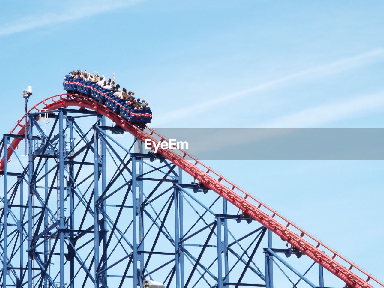 Low angle view of people enjoying big one ride at blackpool pleasure beach against sky