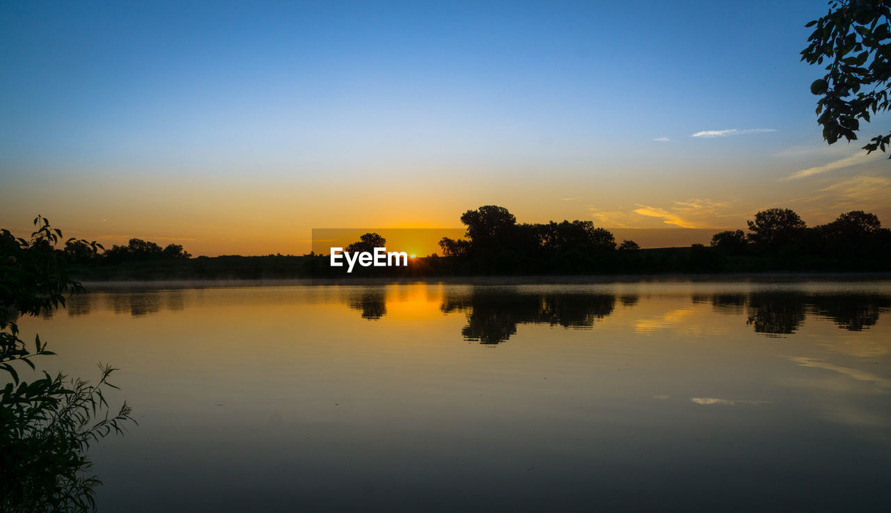 Scenic view of lake against sky during sunset