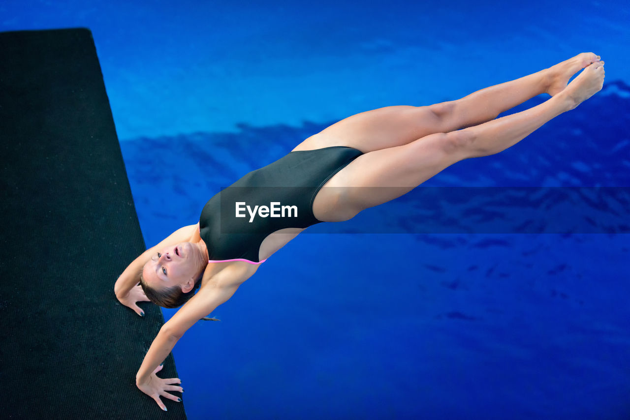 High angle view of woman diving into swimming pool