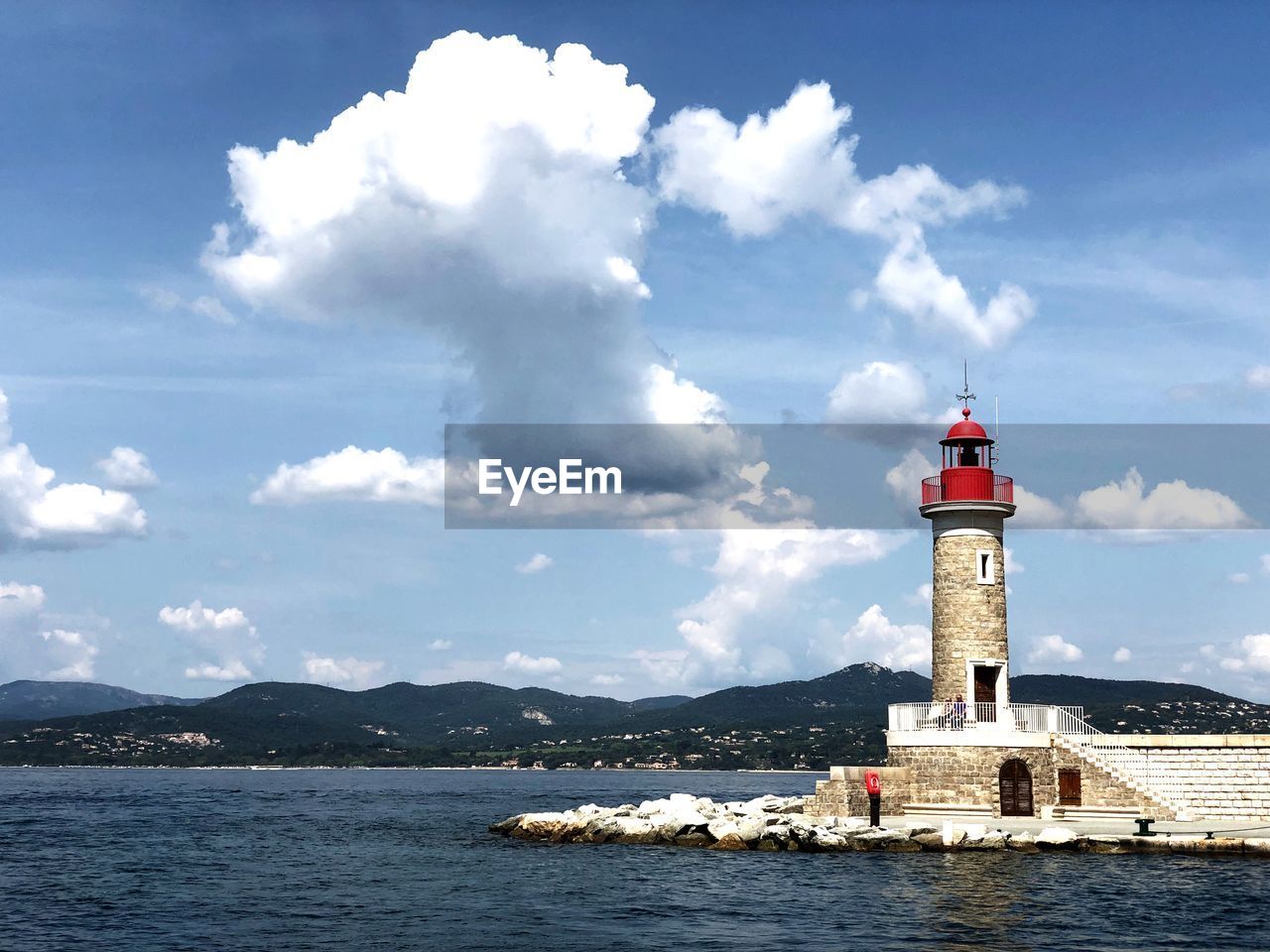 Lighthouse by sea against sky