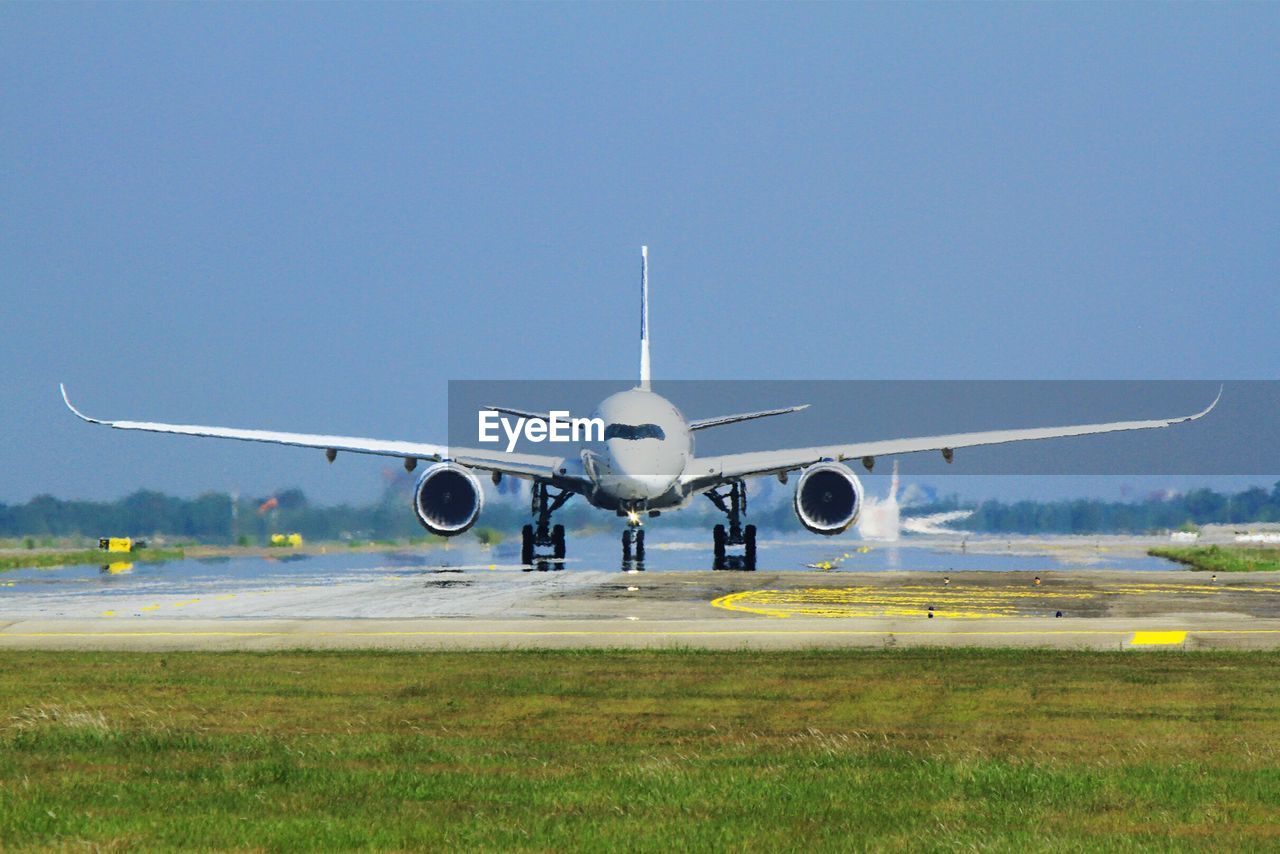 AIRPLANE FLYING OVER FIELD