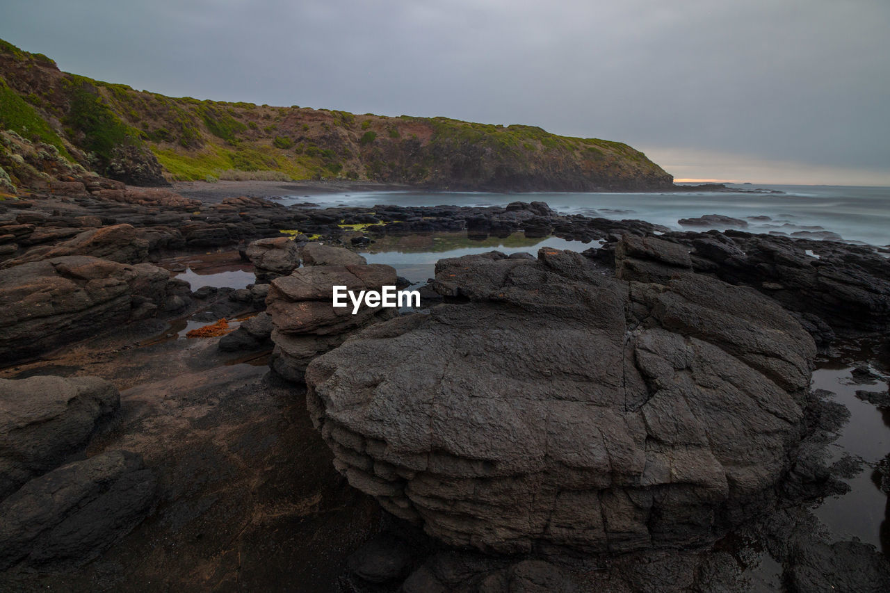 Rocks on beach against sky