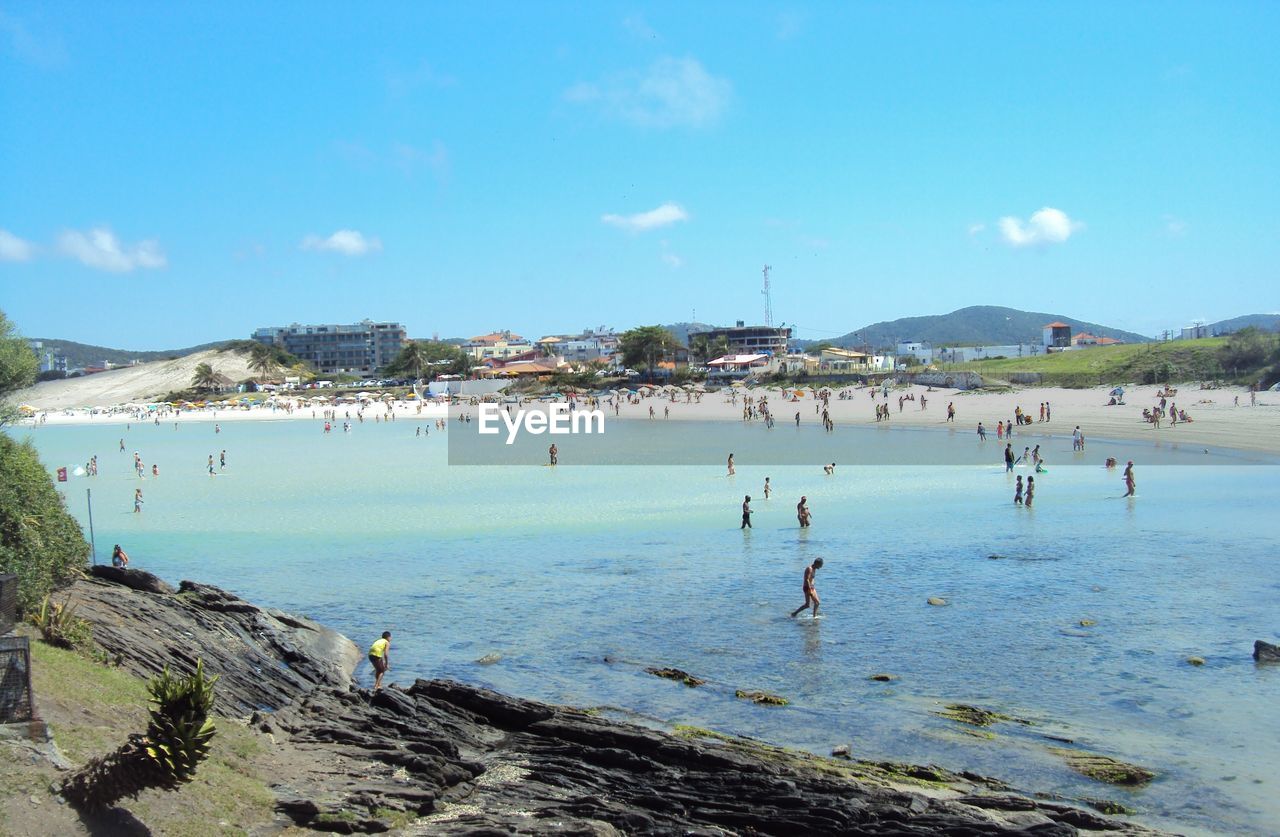 People on beach against blue sky